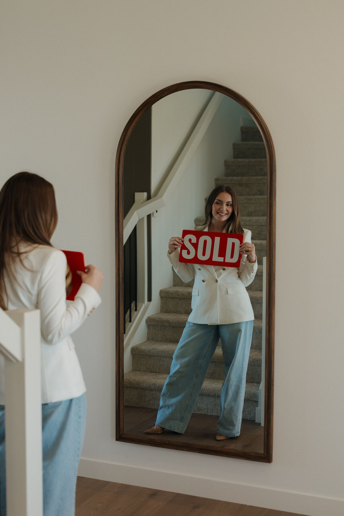 Stephanie Johnston holding a SOLD sign